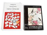 two books on a white table with a red cover and a picture of a bird