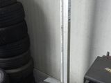 un tas de pneus dans un garage, à côté d'une machine à démonter les pneus
