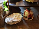 three cakes on a table with plates and cups on it