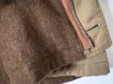 the jacket is brown and tan with a zipper on the side