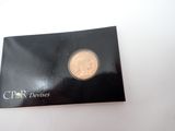 a close up of a coin in a black box on a white surface