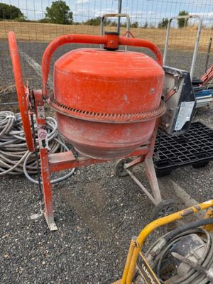 une borne d'incendie rouge posée au sol à côté d'autres équipements