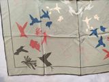 a piece of cloth with birds on it on a table