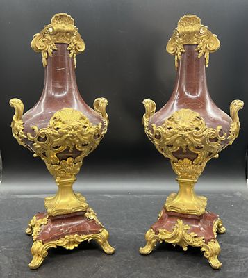 une paire de vases rouges et dorés posés sur une table