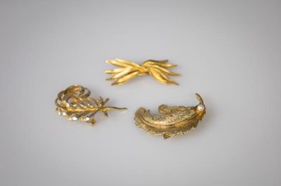 TROIS BROCHES En métal doré A décor de feuillages stylisés