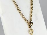 a close up of a gold necklace with a heart on it
