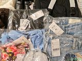 many bags of clothing and a camera on a table