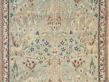 a green and blue rug with a floral design on it
