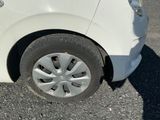 a small white car with a flat tire on the street
