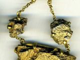 collier composé d'une pépite d'or et de pierres noires et blanches montées sur une chaîne