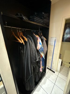 une photo d'un placard avec des vêtements sur des cintres