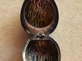 a small silver box with a picture inside of it