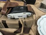 a bag with a camera and a cell phone on a table