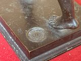 une statue représentant un homme tenant une batte de baseball sur un tapis rouge