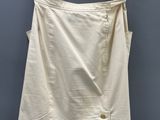 a white skirt hanging on a hanger against a gray wall