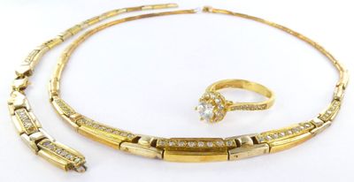 a gold necklace, bracelet and ring with diamonds on a white background