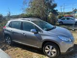 La voiture argentée est garée sur le bord de la route, dans l'herbe.