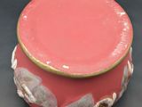a pink box with a gold rim on a black surface