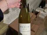 a person holding a bottle of wine in their hand