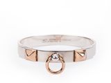 un gros plan d'une bague en argent et en or sur fond blanc