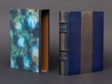 two books with blue covers are sitting side by side on a gray surface
