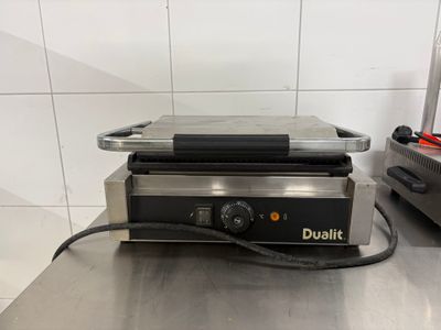 une photo d'un grill professionnel posé sur un plan de travail en acier inoxydable