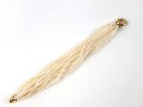 pompon orné de perles avec un fermoir doré sur fond blanc