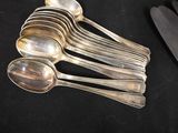 five spoons and a knife on a black table