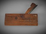 an old wooden box with a knife on top of it