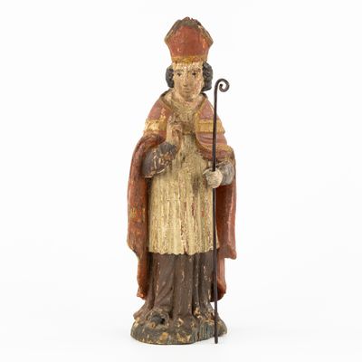 a wooden statue of a man with a cane and a robe