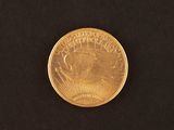 a close up of a gold coin on a black surface
