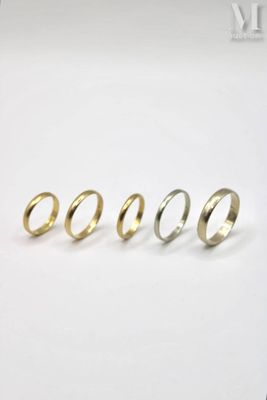 four different types of gold rings on a white surface