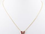 a gold necklace with a pink flower pendant on a white mannequin