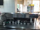 stainless steel counter top with pots and pans on it in a kitchen