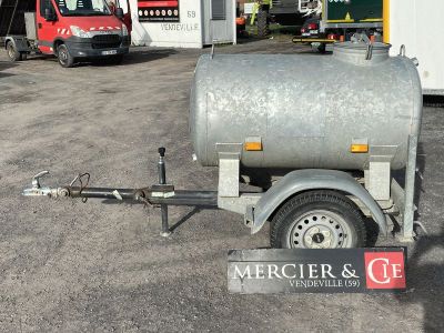 une remorque à laquelle est attelée une citerne, dans un parking