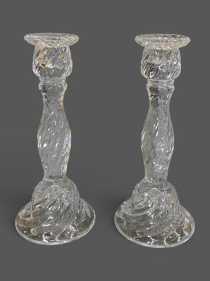une paire de bougeoirs en verre transparent sur fond gris