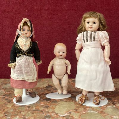 trois poupées qui se tiennent côte à côte sur une table