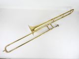 un trombone en laiton posé sur une surface blanche