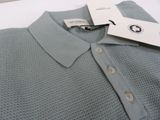 polo shirt with a tag on it sitting on a white surface