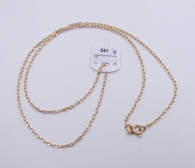 un collier plaqué or muni d'une chaîne qui y est attachée