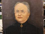 an old painting of a woman in a black dress sitting on top of a wooden table