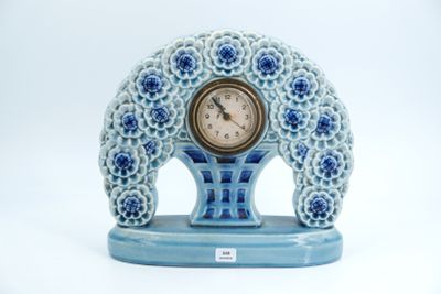 une horloge bleue et blanche posée sur un socle bleu