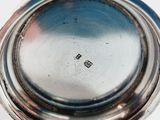a silver plate with a silver lid on a white table