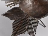 a metal sculpture of a sunburst on a stand