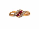gros plan d'une bague en or avec un rubis et des diamants