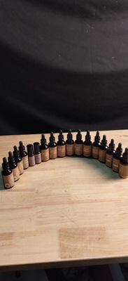 bottles of essential oils lined up on a wooden table with a black background