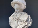 a statue of a woman holding a flower in her hands