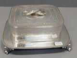 an antique silver plate with a fish on it on a stand