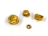 trois pièces de métal doré percées d'un petit trou au milieu