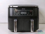 an air fryer sitting on top of a counter next to a white wall